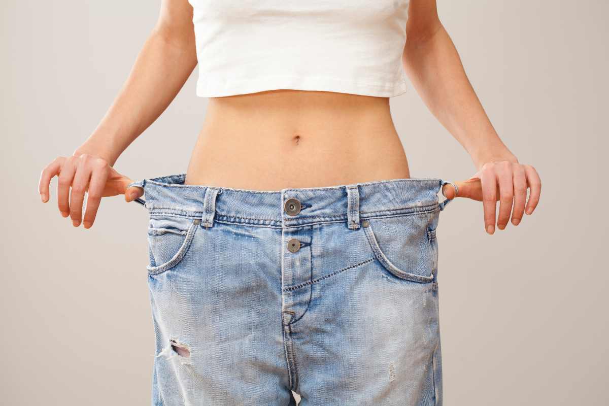 A person showing the fit of jeans after weight loss