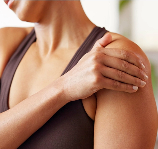 A person holding their shoulder, representing joint discomfort regenerative care can address